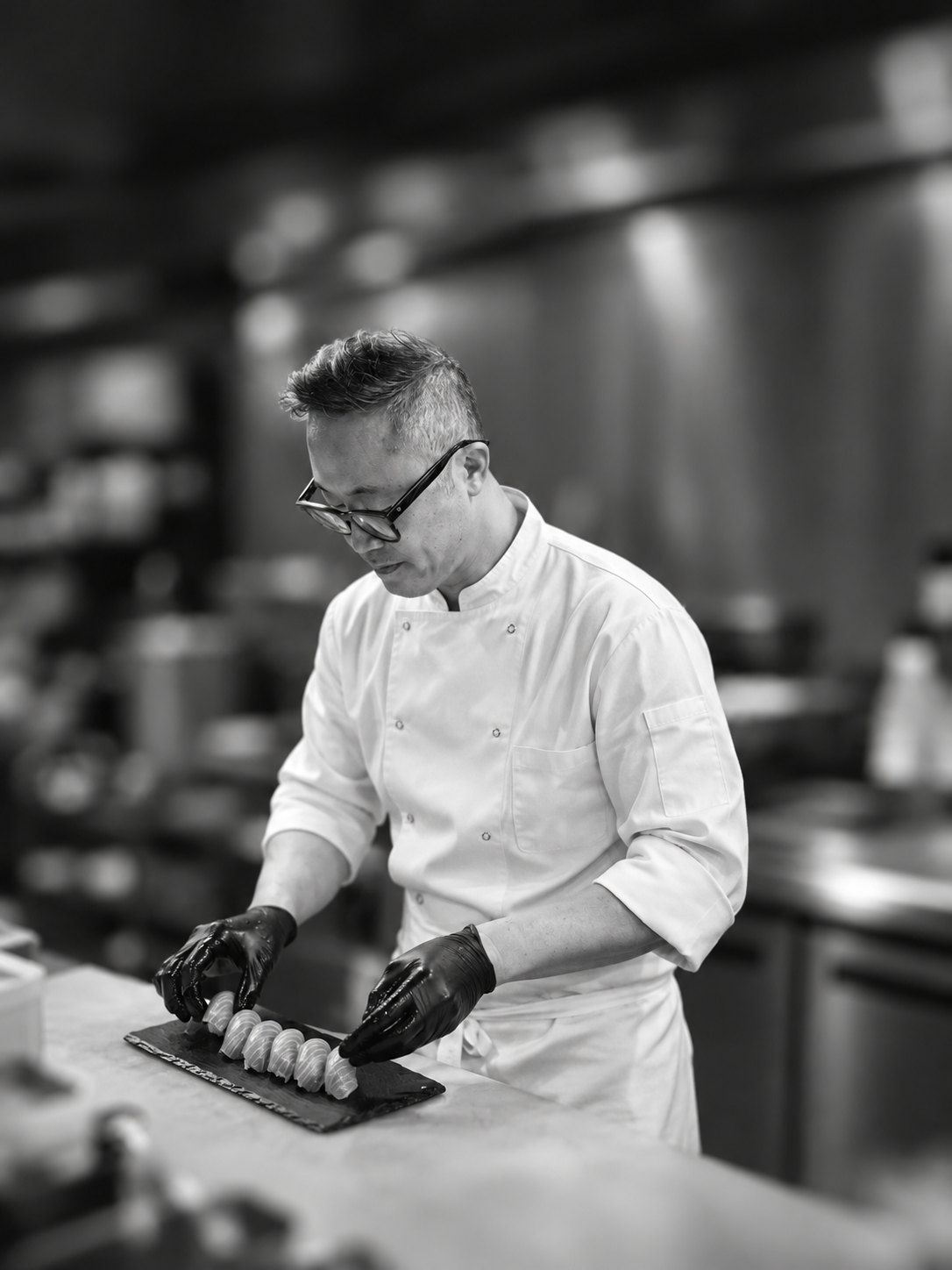 Jong Yeol Lee, owner-chef of Yuzu Merrylands, plating a roll in the kitchen